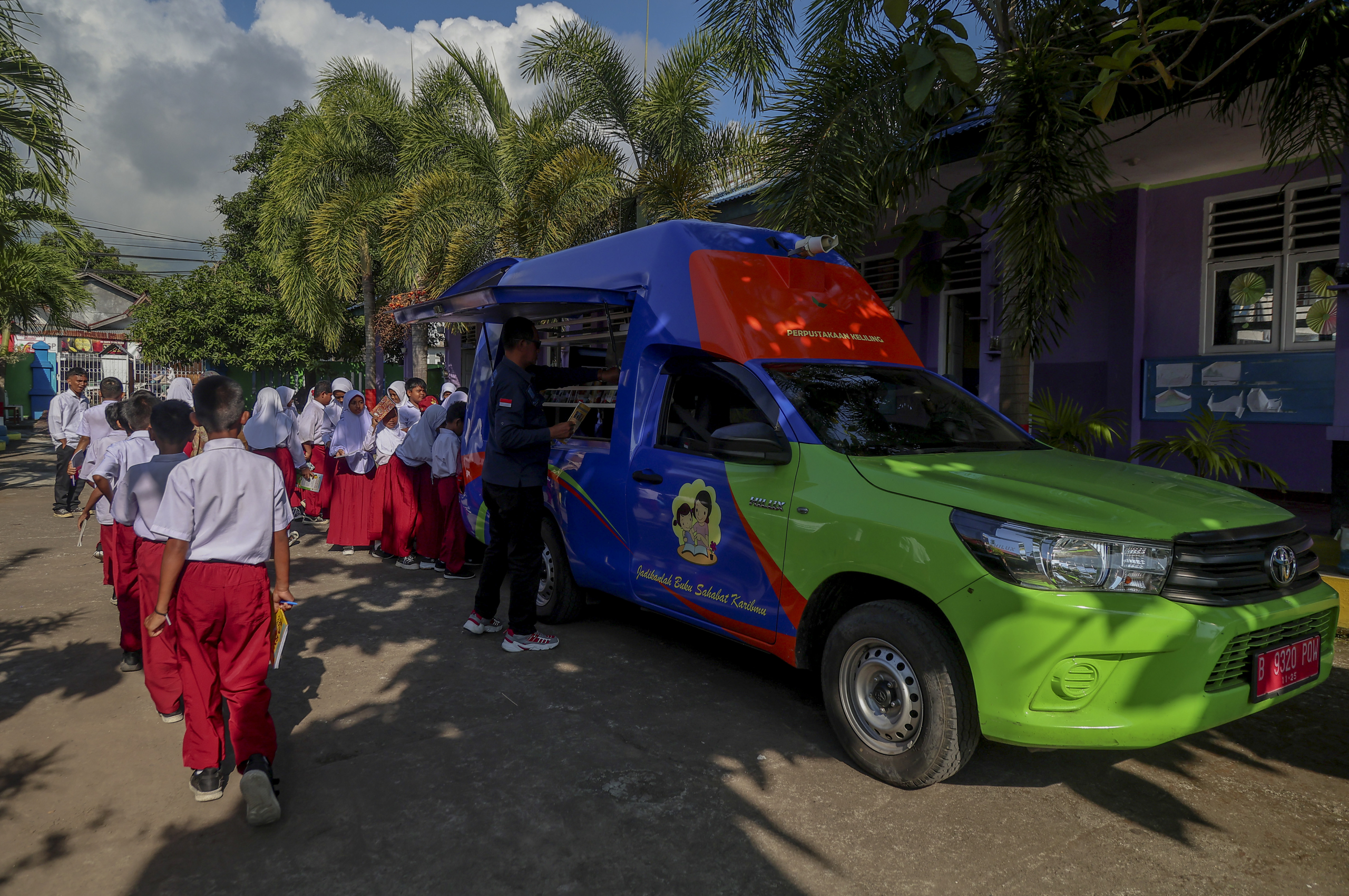 Sejumlah siswa mengantre untuk mengambil buku bacaan yang disediakan Mobil perpustakaan keliling di SD Negeri 50 Kota Ternate, Maluku Utara, Selasa (30/9/2025).Dinas Kearsipan dan Perpustakaan (Disarpus) Provinsi Maluku Utara melakukan jemput bola dengan layanan mobil perpustakaan keliling yang digelar rutin di sejumlah sekolah tingkat SD, SMP, hingga SMA sebagai upaya untuk meningkatkan literasi membaca bagi siswa dan berupaya untuk mencapai target di tahun 2025 tingkat gemar membaca 60-70 persen di Maluku Utara.KOKEHE FOTO/ Azzam.